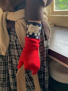 Vue détaillée de gants en tricot bicolore avec motif d'étoiles et étiquette tissée.