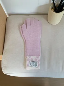 Gants tactiles en tricot rose pour femme avec poignets à pois et jolie étiquette.
