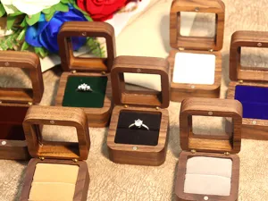 Vue détaillée de la boîte à bague en bois avec couvercle en verre et coussin en velours.