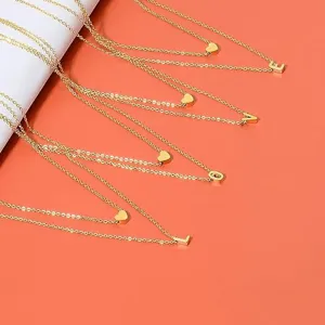 Delicado juego de collares dorados multicapa con dijes de letras y corazones.