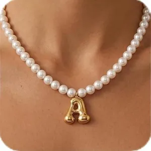 Detailaufnahme der eleganten Perlenkette mit einem massiven goldenen Buchstaben A Anhänger.