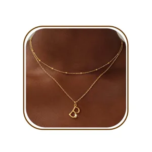 Gedetailleerde close-up van een minimalistische dubbellaagse gouden ketting met letter B hanger.