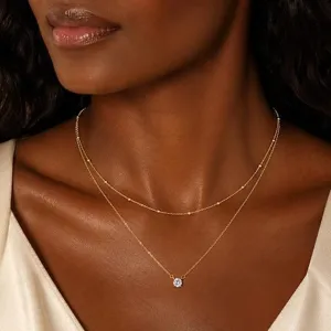 Collier double couche élégant en zircon avec chaîne dorée et pendentif étincelant.