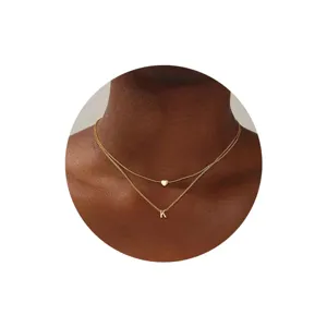 Collar doble dorado elegante con un colgante de corazón delicado y letra K inicial bonita.