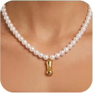 Nahaufnahme Detail der eleganten Perlenkette mit einem polierten goldenen Metallanhänger.