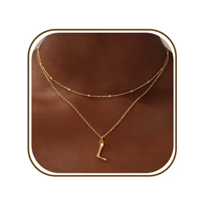Gedetailleerde close-up van het elegante dubbele gouden letter L hanger halsketting ontwerp.