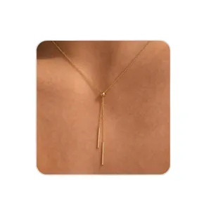 Collier en Y doré minimaliste et exquis avec perle coulissante et pendentifs barres fins.