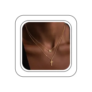 Vue de détail exquise du collier double couche en or lettre M et croix, élégant.