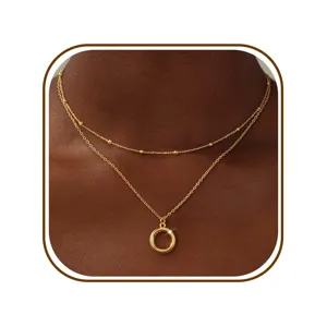 Gedetailleerde close-up van een stijlvolle dubbellaagse goudkleurige ketting met kralen.