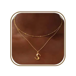 Detailfoto van gouden dubbellaagse letter S hanger halsketting met fijne kralenketting design.