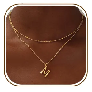 Gouden dubbellaagse ketting met initiele m hanger minimalistische vintage sieraden