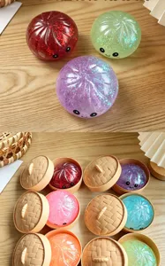 Close-up view of colorful glitter bun squeeze toys with cute faces and mini steamer baskets.