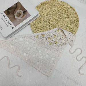 Detailed close-up of handmade crochet knitted triangular scarf, pink woolen hair band accessory.