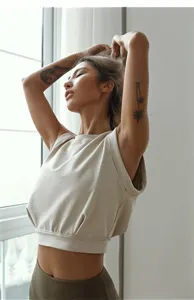 Detail van los mouwloos crop top, zachte ademende stof ideaal voor yoga en dagelijkse vrijetijd.