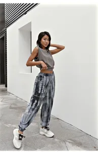 Dames zomer casual mouwloze crop top en stijlvolle tie-dye jogger broek detail.