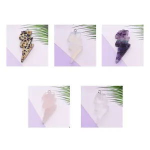 Vista de detalle que muestra colgantes de piedra natural en forma de rayo para joyería DIY.