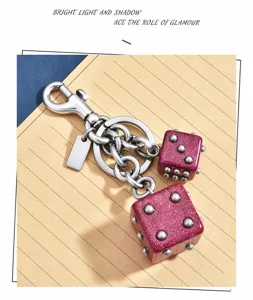 Gros plan détaillé du pendentif porte-clés double dés élégant avec finition pailletée.