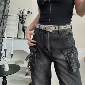 Vue détaillée de la ceinture de taille strassée brillante avec boucle lourde et œillets.