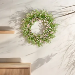 Artificial eucalyptus floral wreath detail shot, green and pink wall hanging decor.