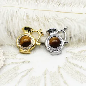 Detailed view of metal pitcher shaped pendant with tiger eye stone and micro-paved crystals.