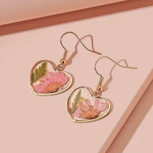 Goldfarbene Harz-Ohrringe mit echten getrockneten rosa Blumen in Herzform eleganter Schmuck.