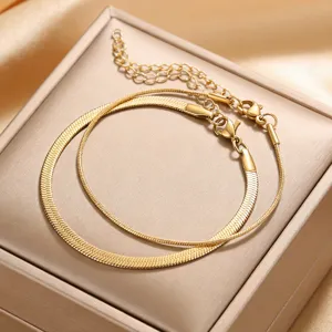 Detailed closeup of a stylish double layer gold snake chain bracelet neatly displayed in a box.
