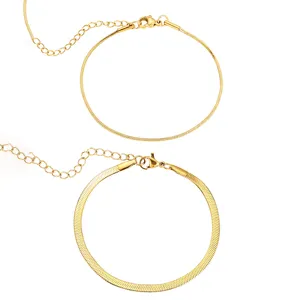 Close-up detail of minimalist gold-plated snake chain bracelets with extension and lobster clasp.