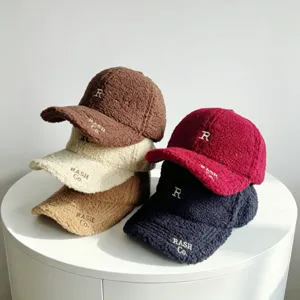 Détail casquette baseball en tissu peluche, bonnet hiver chaud avec broderie et visière.