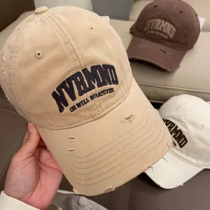 Close-up detail of distressed baseball cap with embroidery, soft top and casual style.