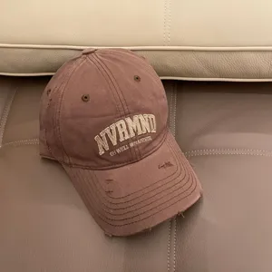 Distressed brown baseball cap with embroidered lettering, casual cotton dad hat for women.