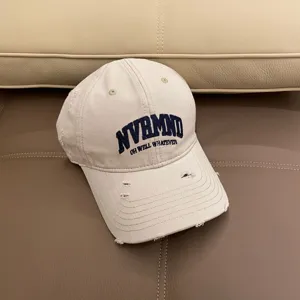 Close-up of distressed beige baseball cap with embroidery detail for casual wear.