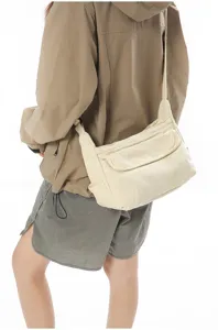 Detailed view of casual Japanese retro canvas messenger bag worn on shoulder, solid color.