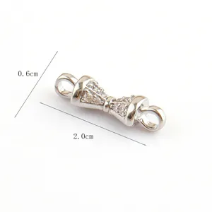 Detailed close-up view of a delicate silver-colored bow-shaped jewelry connector with sparkling stones.