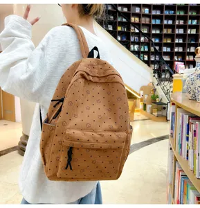 Vue détaillée du sac à dos en velours côtelé montrant une texture douce, un motif et des poches.