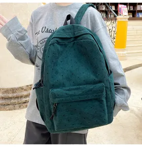 Vue détaillée du sac à dos en velours côtelé vert foncé avec motifs d'étoiles et poche.