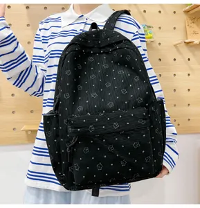 Vue détaillée d'un sac à dos en velours côtelé noir avec motifs d'étoiles et de pois blancs.