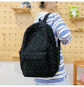 Vue détaillée du élégant sac à dos en velours côtelé noir avec motif d'étoiles sur modèle.