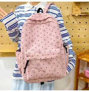 Vue détaillée du sac à dos d'école en velours côtelé rose avec des étoiles et des pois mignons.