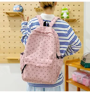 Vue de détail du sac à dos en velours côtelé rose avec motif d'étoiles et poche avant.
