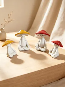Detailed view of cute meditating mushroom figurines with red and yellow caps for home decor.
