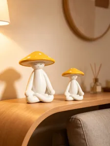 Detail shot of minimalist ceramic meditation mushroom figurines in a cozy warm home decor setting.