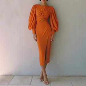 Detailed view of the elegant orange midi dress featuring dramatic puff sleeves and front twist.