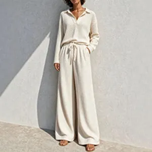 Beige knit lounge set featuring long sleeve V-neck polo top and elegant wide leg trousers.