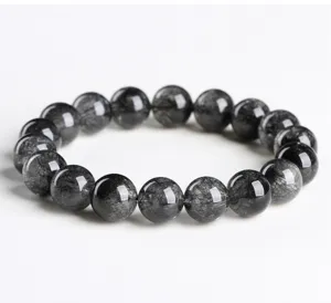 Close-up detail shot of natural black rutilated quartz bead bracelet, stunning needle inclusions