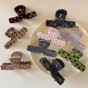 Vue détaillée de pinces à cheveux à pois assorties en plusieurs couleurs pour le style.