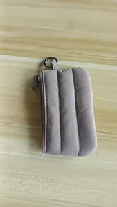 Close-up of quilted mini coin pouch with secure zip closure and keyring accessory.