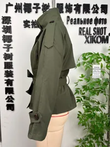 Detailed view of the army green women short trench coat with belt and epaulets on display.