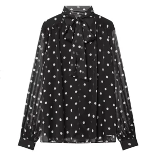 Close-up detail of the black and white polka dot long sleeve blouse with elegant tie neck.