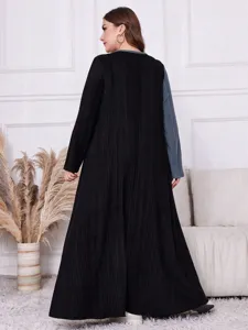 Detailaufnahme des Oversize Kontrastarm Strickkleides in langer Passform hinten.