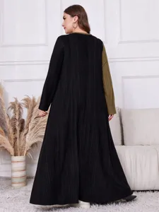 Detailansicht des langärmeligen Plus-Size-Color-Block-Strickkleids im gemütlichen Interieur.